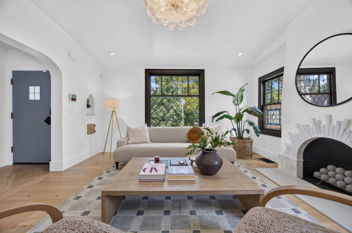 Attention to authenticity and detail is found in the living room, which a traditional 1920s sunburst brick pattern on the fireplace remains intact under a new marble surround and quartzite slab hearth. There is a rounded, vaulted ceiling, exposed beams and a hand‑blown light fixture.